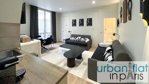 En moderne lejlighed med spiseplads, sofa og køkken.