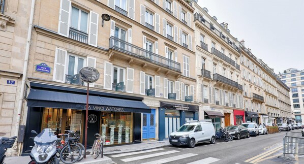 A street view with a row of parked cars, a white van, and bicycles. - Urban Flat 62 - Grand Apartment next to Champs Elysees (París)