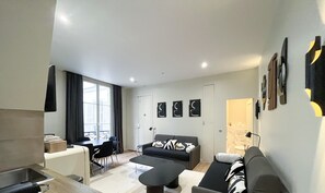 Un apartamento moderno con comedor, sofá y cocina.
