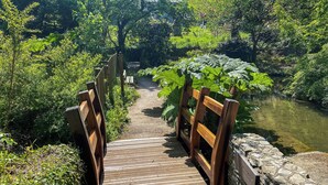 A wooden bridge leading to a stone wall with a plaque. - 4 bedroom accommodation in St Mawes (St Mawes)
