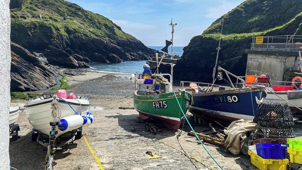 Boats docked at a rocky shore with a sea view. - 4 bedroom accommodation in St Mawes (St Mawes)