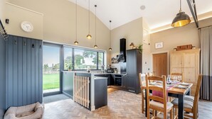 Una cocina moderna con comedor, ventanas amplias y una cama para mascotas.