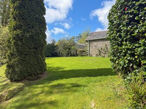 A well-maintained lawn with a stone building in the background.