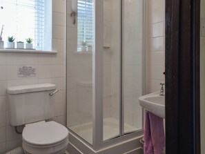 Un baño con inodoro, ducha envuelta en vidrio y lavamanos.