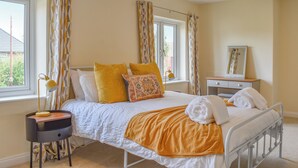 A bedroom with a bed, a bedside table with a lamp, a dresser, and a mirror. - 3 bedroom accommodation in Eakring (Eakring)