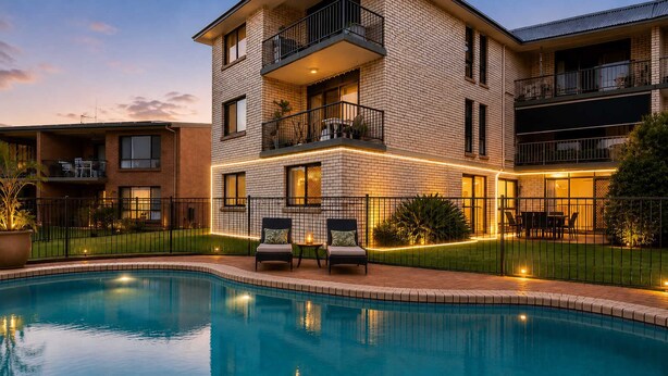 Un immeuble à plusieurs étages doté d’une piscine, d’un espace extérieur aménagé et d’un balcon bien éclairé.