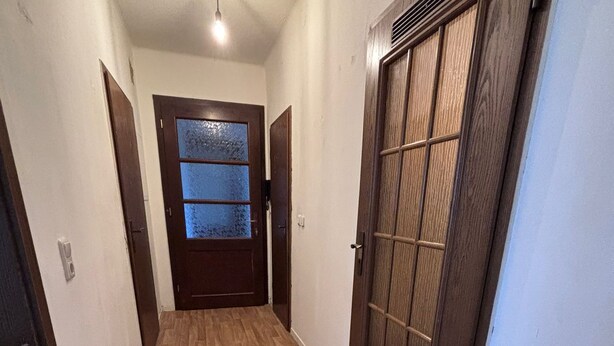 A hallway with wooden flooring, a door with frosted glass panels, and a vent on the wall. - Spacious Central 3Bedroom flat for 8 guests (Zeitz)