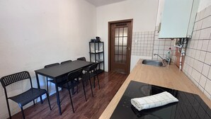 A compact kitchen with a wooden countertop, a built-in stove, and a sink. - Spacious Central 3Bedroom flat for 8 guests (Zeitz)