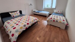 A room with two beds, a window, and a radiator. - Spacious Central 3Bedroom flat for 8 guests (Zeitz)