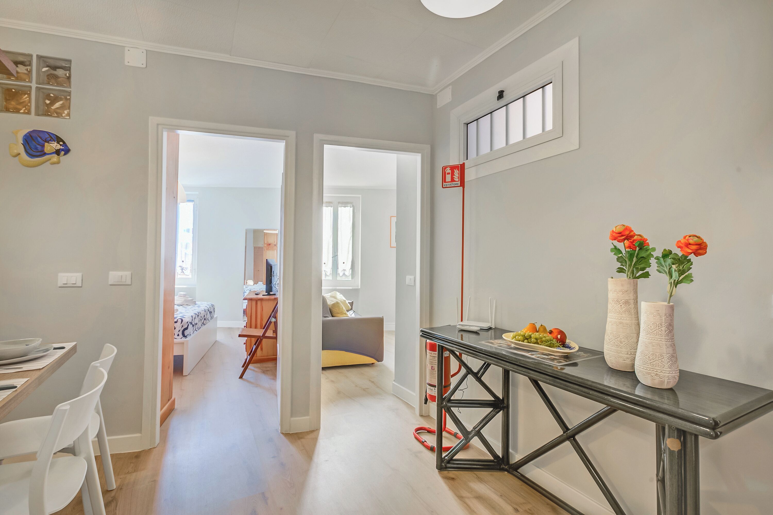 Een moderne keuken met een eethoek, een gang naar een andere kamer en een brandblusser aan de muur.