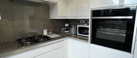 Een microgolfoven, een oven, een kookplaat, een vaatwasser