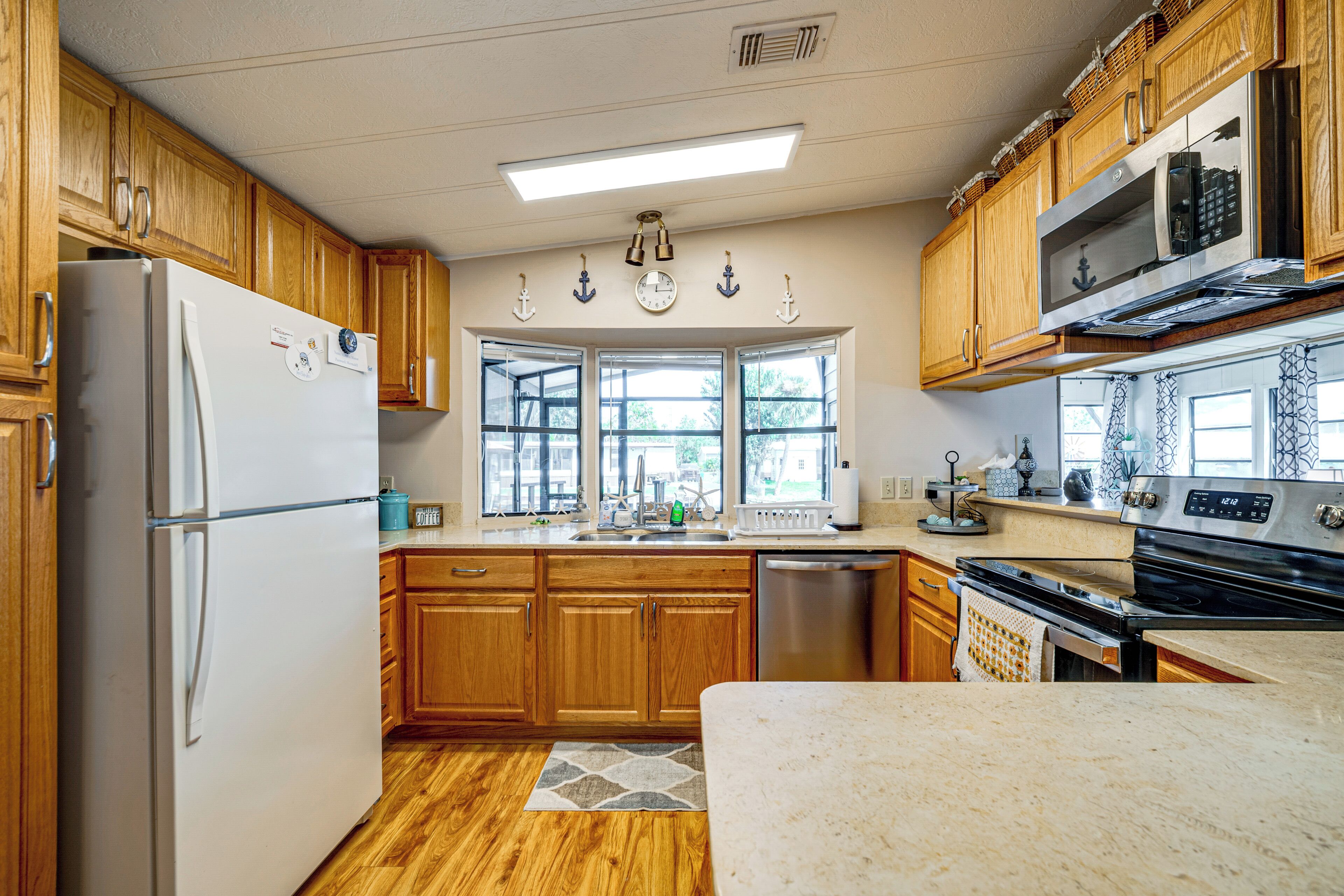 A kitchen with wooden cabinets, a refrigerator, a stove, and a microwave.