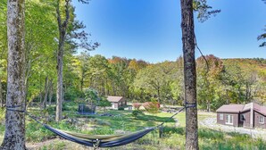 A hammock between trees in a forested area with a house and a playground in the background. - Ice Fish, Snowshoe & Ski: Group Getaway in Summit (Summit)