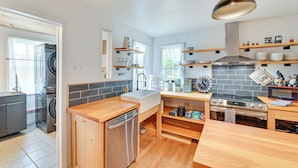 A modern kitchen with wooden countertops, a built-in dishwasher, a stove, and a hanging light fixture. - Ice Fish, Snowshoe & Ski: Group Getaway in Summit (Summit)