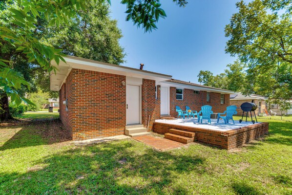 A brick house with a patio area featuring blue chairs and a barbecue grill. - 6 Mi to Dtwn Pensacola: Family-friendly Gem! (Pensacola)