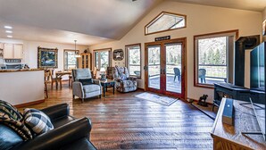 A spacious living room with hardwood floors, a fireplace, and a large TV. - Hike, Fish & Unwind: Remote Escape in Montana (St. Regis)