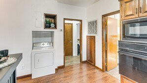 A kitchen with a stove, oven, and wooden cabinets. - Close to Hospital & Dtwn! Quiet Waycross Home (Waycross)