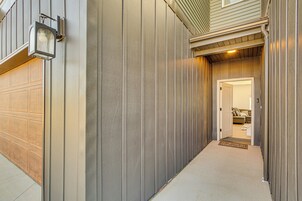 A narrow, covered walkway leading to a garage and a door to a living area.