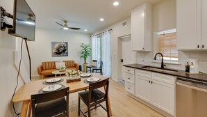 A modern kitchen with white cabinets, a black countertop, and a built-in dishwasher. - Duplex w/ Furnished Patio Near Lake Ouachita! (Jessieville)