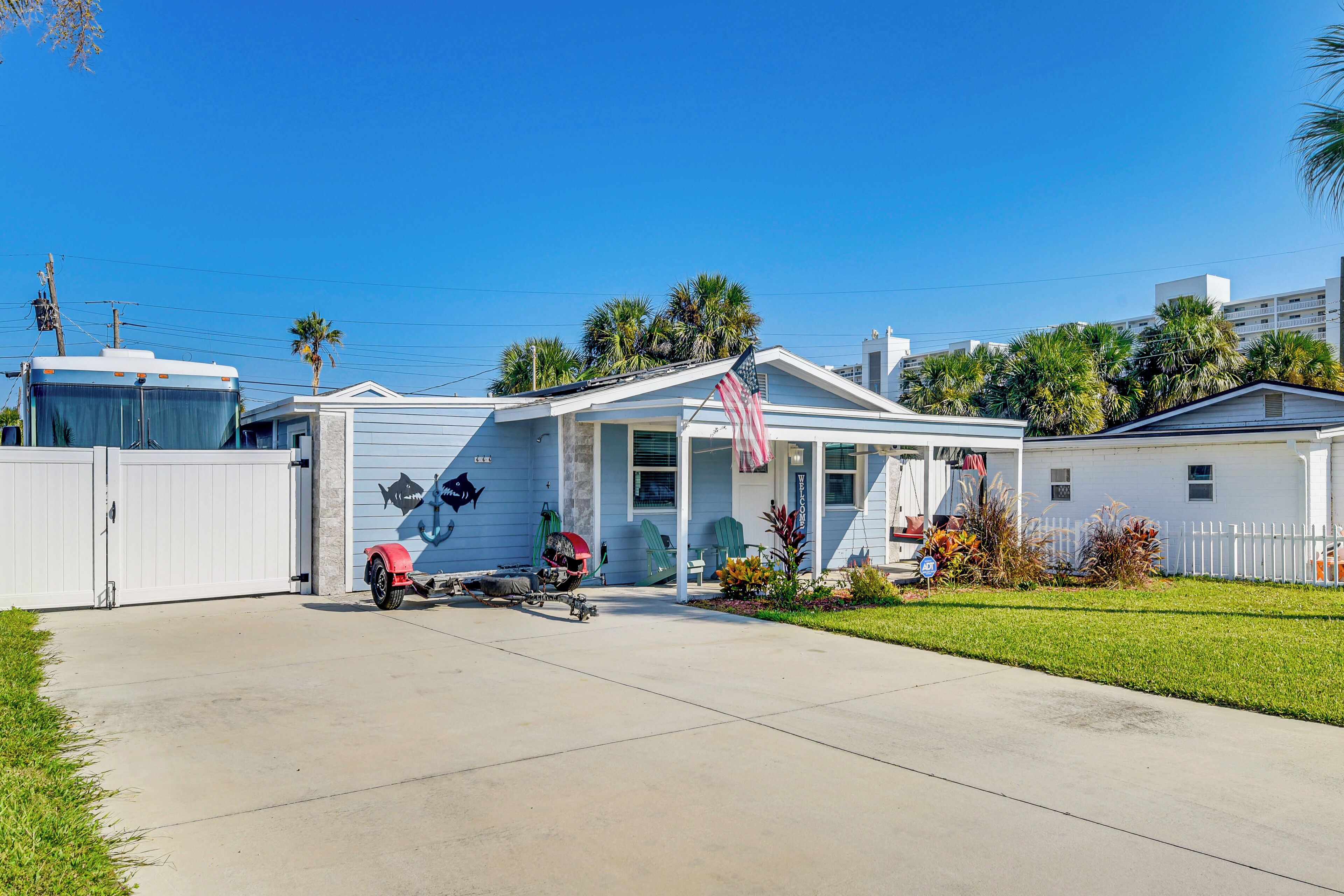 A single-story house with a garage, a small porch, and a flag.