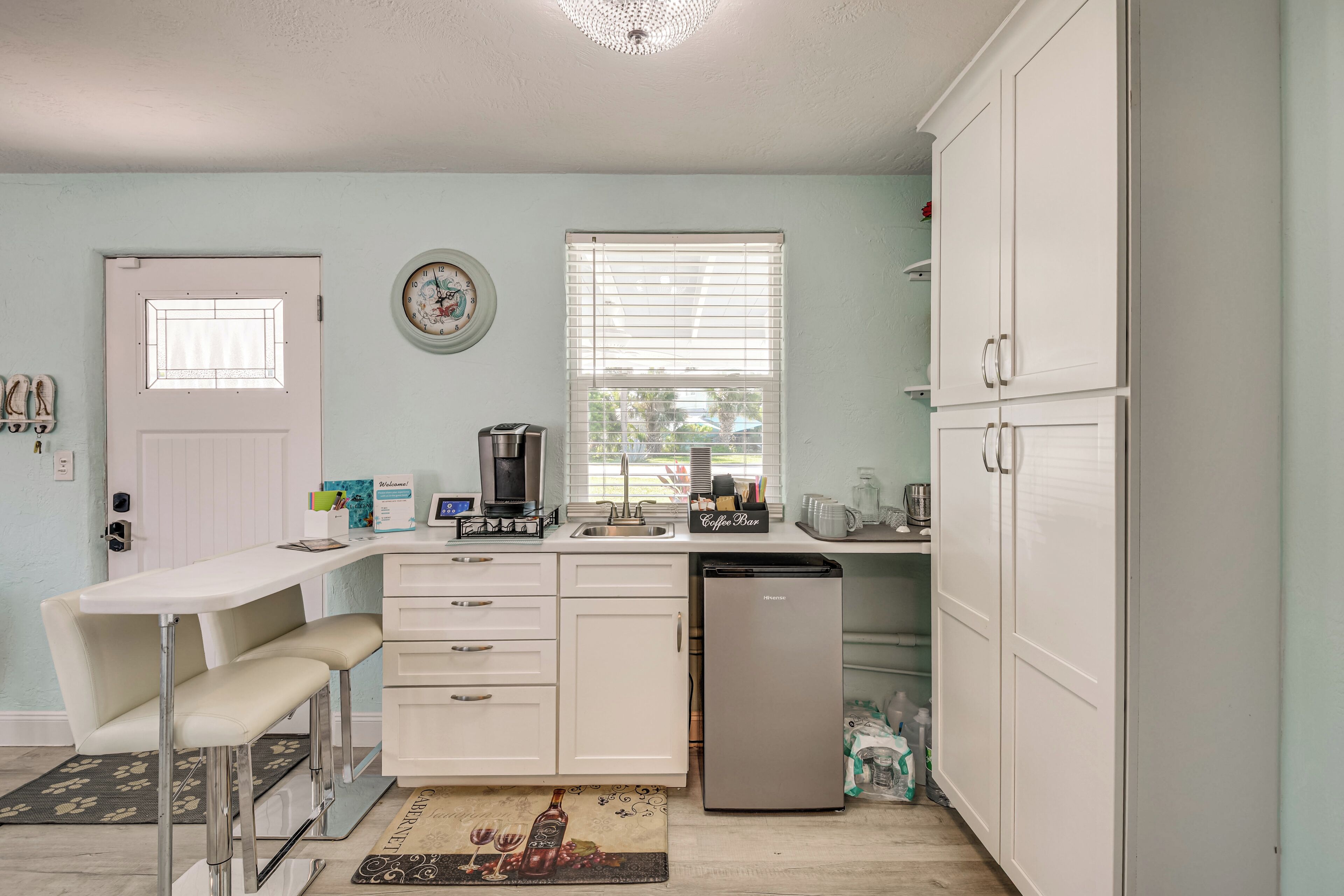 Cocina compacta con cafetera, refrigerador y lavabo.