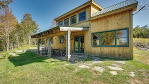 A wooden cabin with a covered patio and a large window. - Unplug, Unwind & Explore: Remote Vermont Cabin (Sharon)
