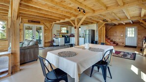 A wooden cabin interior with a dining area, kitchen, and living space. - Unplug, Unwind & Explore: Remote Vermont Cabin (Sharon)