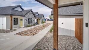 Un quartier résidentiel moderne où les maisons se distinguent par leurs façades en pierre et en bois, une allée pavée et un chemin recouvert de gravier.