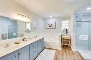 A bathroom with a large mirror, a sink, a bathtub, and a shower. - Quiet Countryside Getaway in Appalachian Foothills (Commerce)