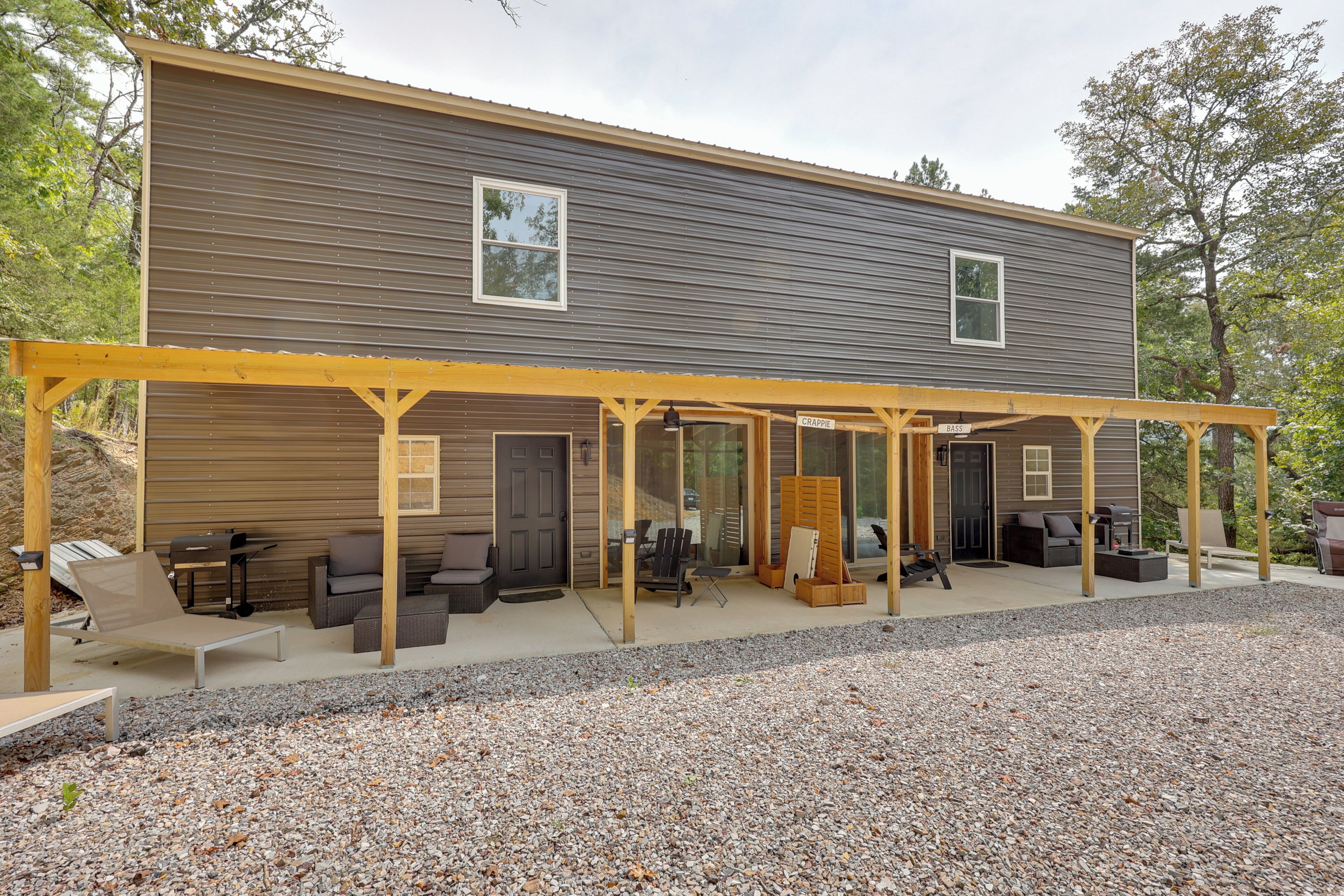 A two-story house with a covered patio area featuring outdoor furniture and a grill.