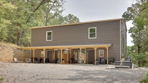 A two-story building with a covered patio area, outdoor seating, and a grill.