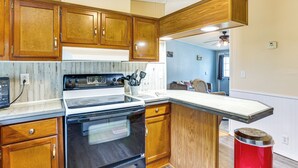 A kitchen with wooden cabinets, a stove, and a countertop. - 3 Mi to Dtwn: Pet-friendly Farm Retreat in Paris! (Paris)