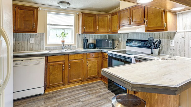 A kitchen with wooden cabinets, a dishwasher, a microwave, and a stove. - 3 Mi to Dtwn: Pet-friendly Farm Retreat in Paris! (Paris)