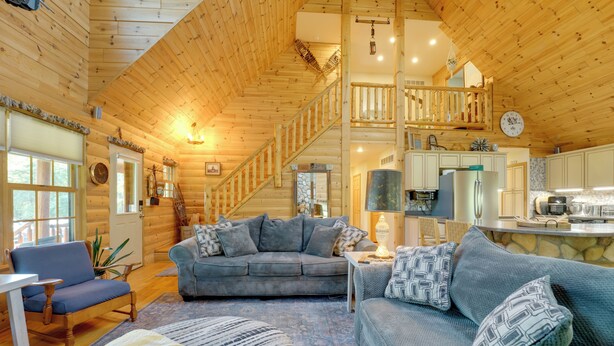 A wooden cabin interior with a living room, kitchen, and a staircase. - Port Austin Cabin w/ Hot Tub: 1 Mi to Beach! (Port Austin)