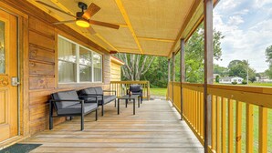 Eine Holzterrasse mit Deckenventilator, einer Couch und einem Tisch.