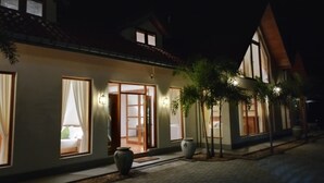A hotel with a traditional architectural style, featuring large windows, a wooden door, and a paved walkway. - Turtle bay View Private Villa Down South Talpe Srilanka (Unawatuna)
