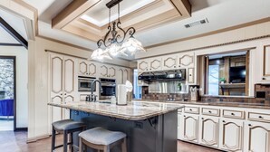 Una cocina amplia con una isla grande, electrodomésticos integrados y elegantes armarios.