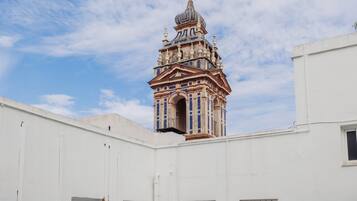 Ein weißes Gebäude mit einem Glockenturm, der reich verzierte architektonische Details aufweist.