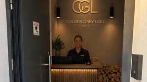 A reception desk with a sign reading 'Golden Grey Loey Loft' and a receptionist.