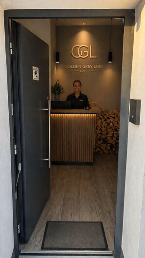 Un comptoir d’accueil avec une pancarte indiquant « Golden Grey Loey Loft » et un réceptionniste.