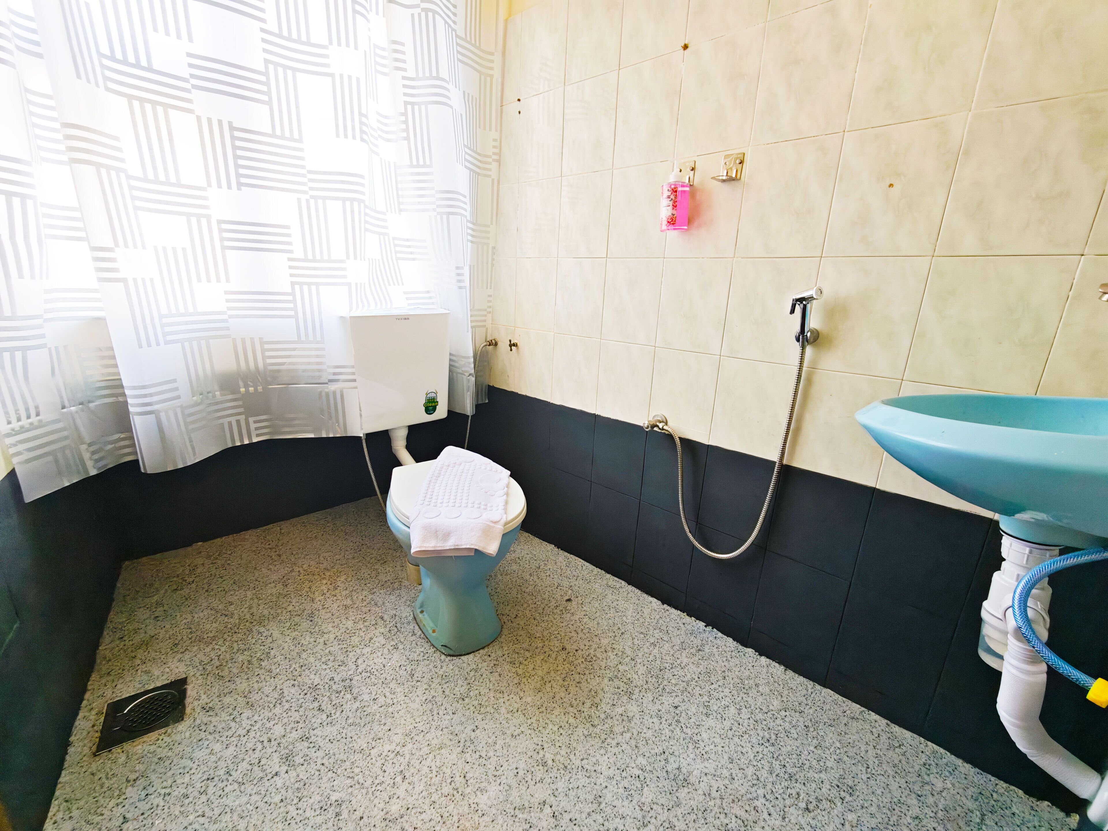 A bathroom with a toilet, shower, and sink.