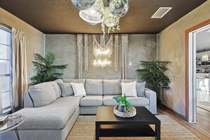 Una sala de estar moderna con un sofá modular, una mesa de centro y plantas decorativas.
