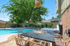 A backyard with a swimming pool, outdoor furniture, and a hot tub. - Luxury 5BR Getaway w/ Pool, Hot Tub & Cinema (DeSoto)