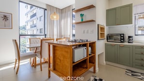 A modern kitchen with green cabinets, a microwave, and a toaster. - Apart w/ Barbecue 800m From the Beach Sre1403 (Itapema)