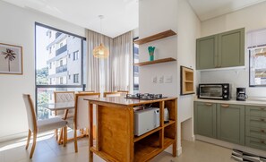 Une cuisine moderne avec des meubles de couleur verte, un four à micro-ondes et un grille-pain.