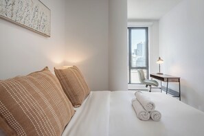 2 habitaciones, escritorio y tabla de planchar con plancha