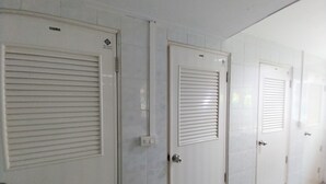 A row of white doors with horizontal louvered panels, each with a small logo above the door.