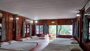 A room with wooden walls and multiple beds arranged in a row.