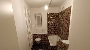 Une petite salle de bain comprenant des toilettes, une baignoire et un lavabo.