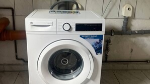 Une machine à laver à chargement frontal dotée d’un écran numérique et d’une étiquette indiquant une capacité de 7 kg.